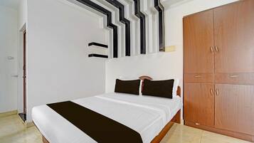 Ein Schlafzimmer mit einem Bett, einem Kleiderschrank und einer Wand mit geometrischem Muster.