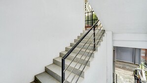 Eine Treppe mit schwarzer Metallgeländer, die zu einer oberen Etage führt.