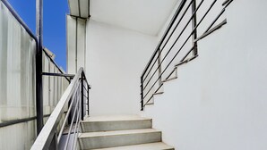 Eine Treppe mit Metallgeländern, die zu einer weißen Wand führt.