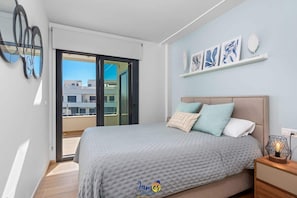 A modern bedroom with a large bed, a nightstand, and a view of the city through a sliding door. - Paradise 77 Penthouse with Private Jacuzzi  VM65 (Villamartín)