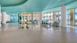 Eine geräumige Lobby mit himmelblauer Decke, großen Fenstern und modernen Möbeln.