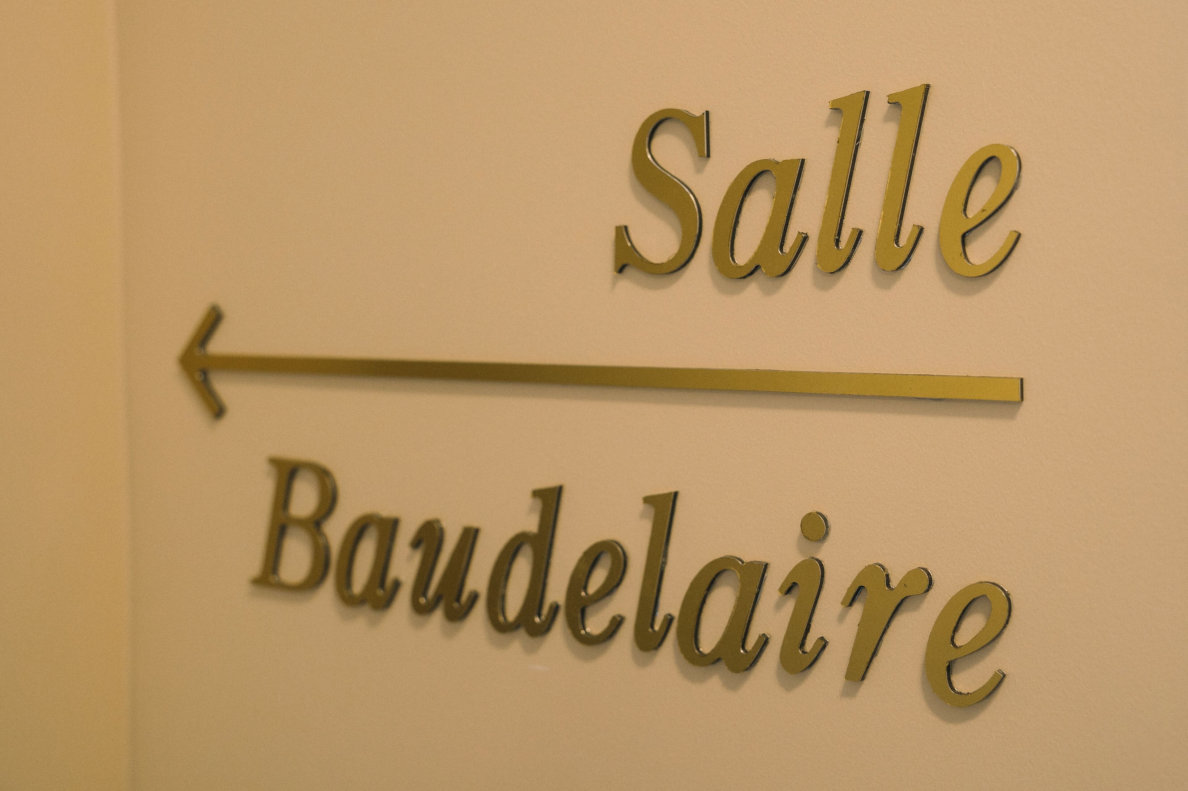 A sign with the words "Salle" and "Baudelaire" indicating directions.