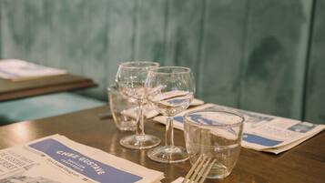 A table with a menu, wine glasses, and a glass of water.