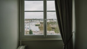 Una finestra con vista su un porto turistico e degli edifici.