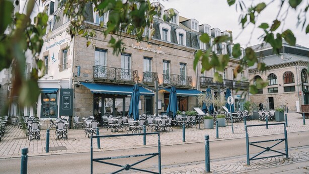 Un edificio con posti a sedere all'aperto e un caffè chiamato "Les Grandes Voilages".