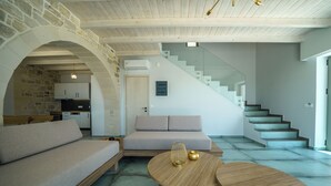 Un salon moderne avec un canapé, une table basse et un escalier.