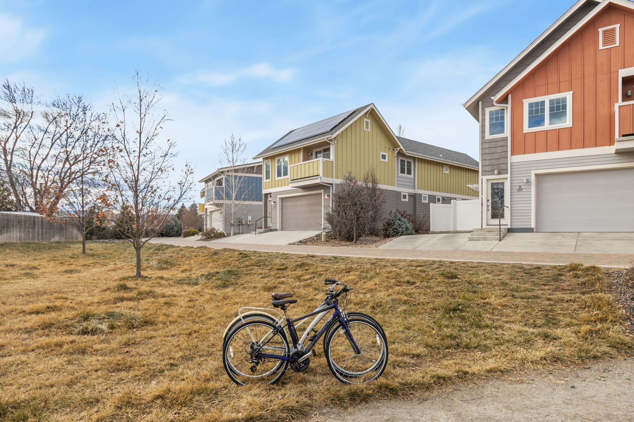 A residential area with houses, a bicycle, and a clear sky.