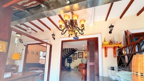 Un hall espacioso con techo alto, un candelabro y una escalera que sube a los pisos superiores.
