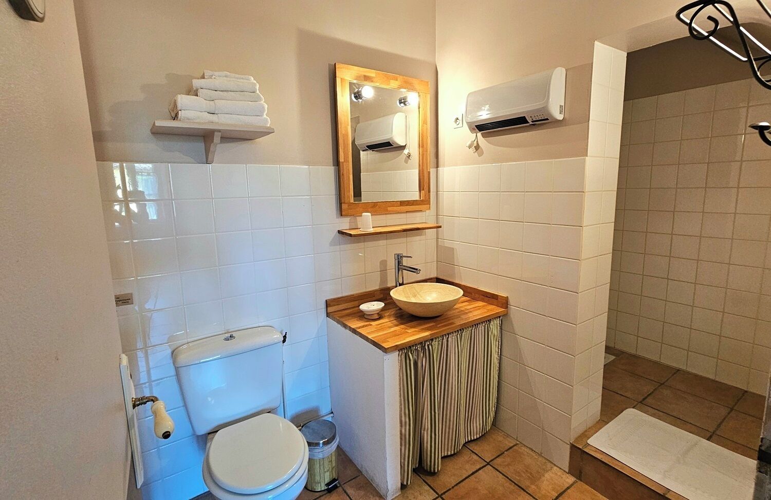 Een kleine badkamer met toilet, wastafel en douche.