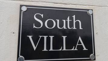 Un letrero negro con letras blancas que dice "South VILLA".