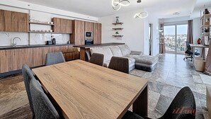Eine moderne Küche mit Holzausstattung, einem eingebauten Ofen und einem Essbereich mit einem Holztisch und Stühlen.