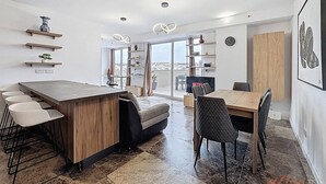 Eine moderne Küche mit einer zentralen Kochinsel, Barhocker und einem Essbereich mit einem Holztisch und Stühlen.