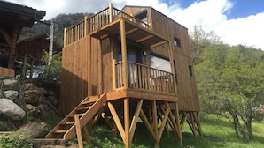 En træhytte med balkon og trappe.