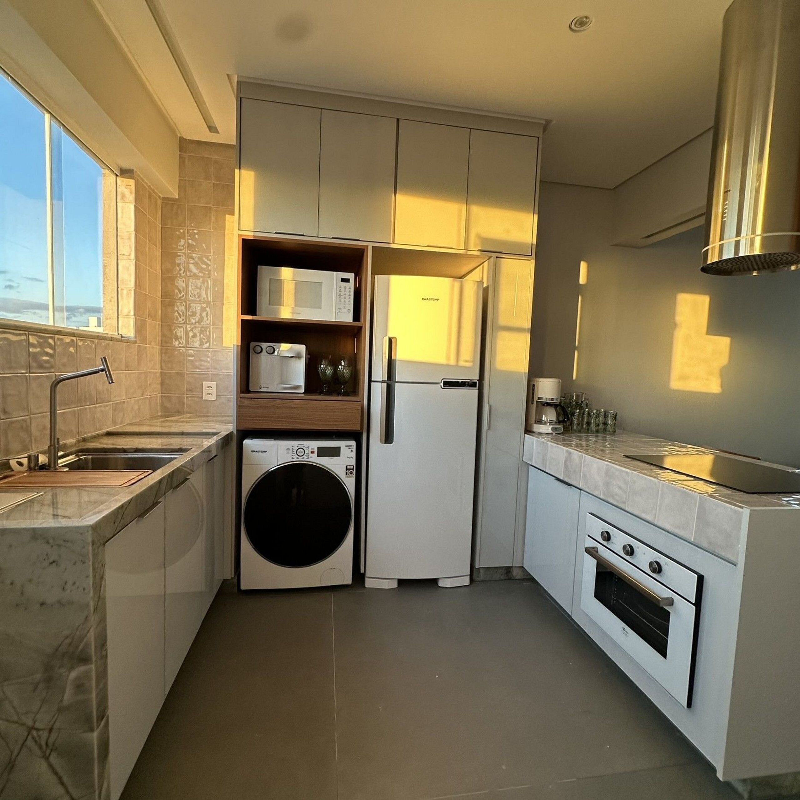 A compact kitchen with a built-in washer, microwave, refrigerator, and oven.