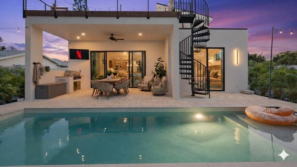 Uma casa moderna com piscina, área de refeições e escada em espiral.
