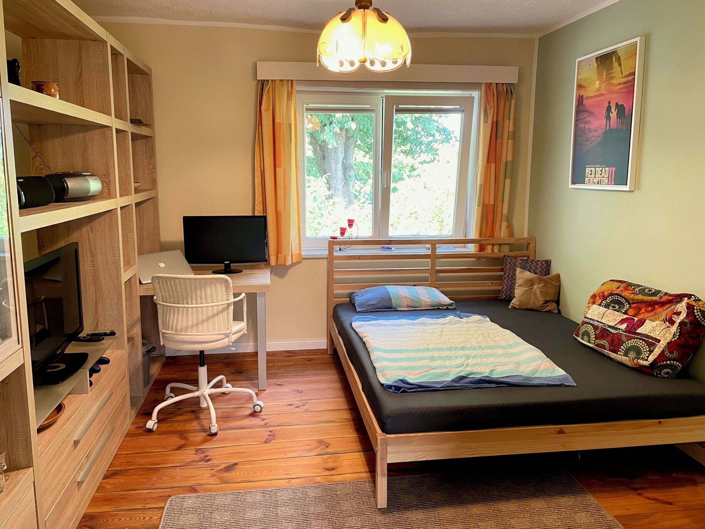 A bedroom with a bed, desk, chair, and shelves.