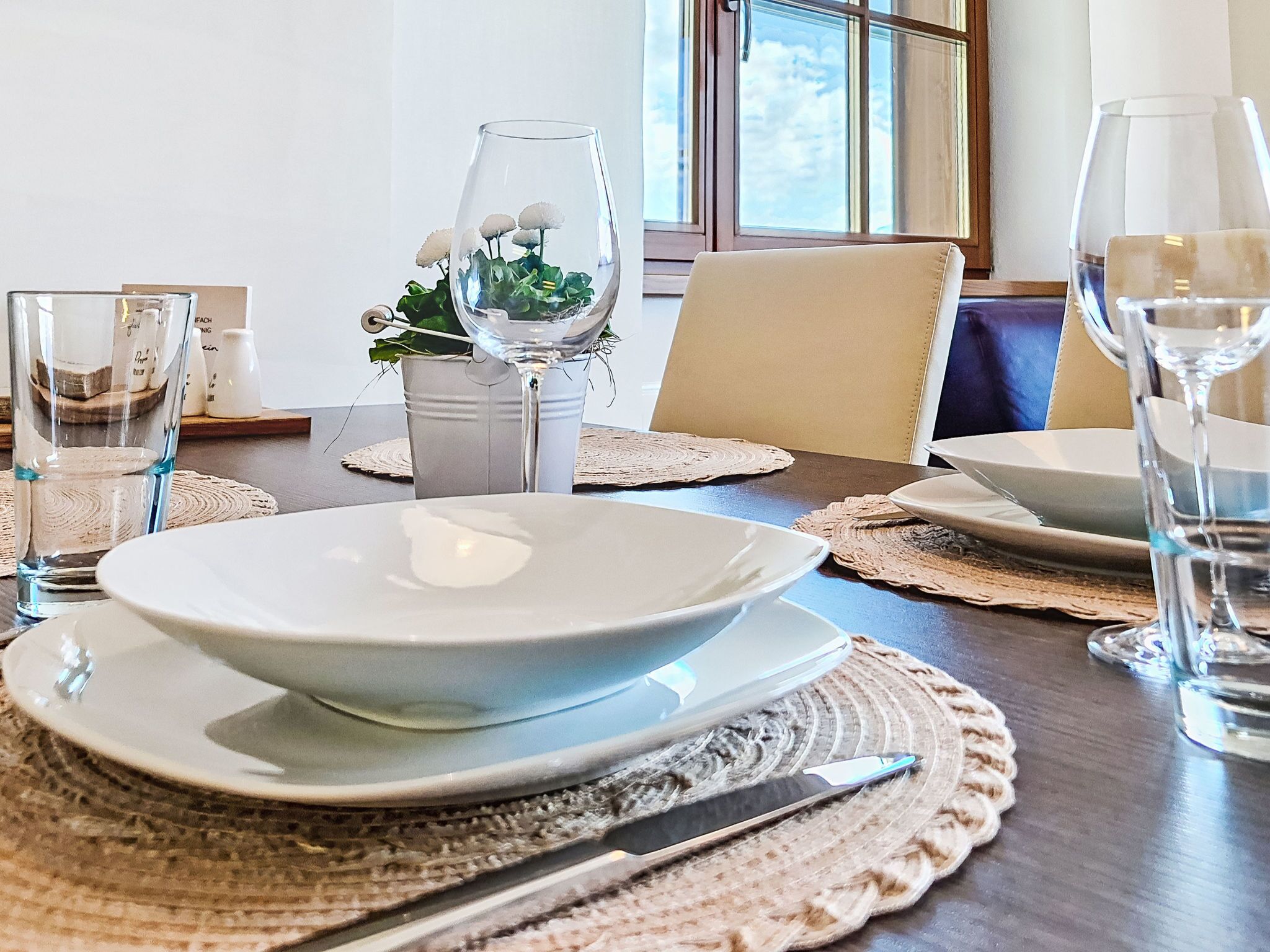Una mesa puesta con platos, vasos y un cuchillo.