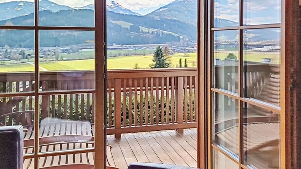 Un balcon avec vue sur les montagnes et la ville.