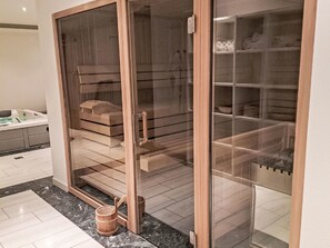 Ein modernes Badezimmer mit einer gläsernen Dusche, einer Holzbank und einer Badewanne.