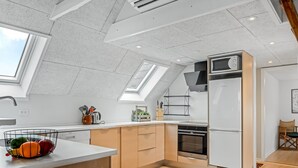 Una cocina moderna con tragaluces, horno empotrado y refrigerador.