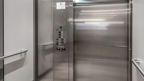A modern elevator with stainless steel doors, a control panel, and a digital display. - Bright New 2BR in Tekamah at Tiger Town (Tekamah)
