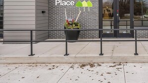 A storefront with a sign reading "TigerTown Place" and a brick wall. - Bright New 2BR in Tekamah at Tiger Town (Tekamah)