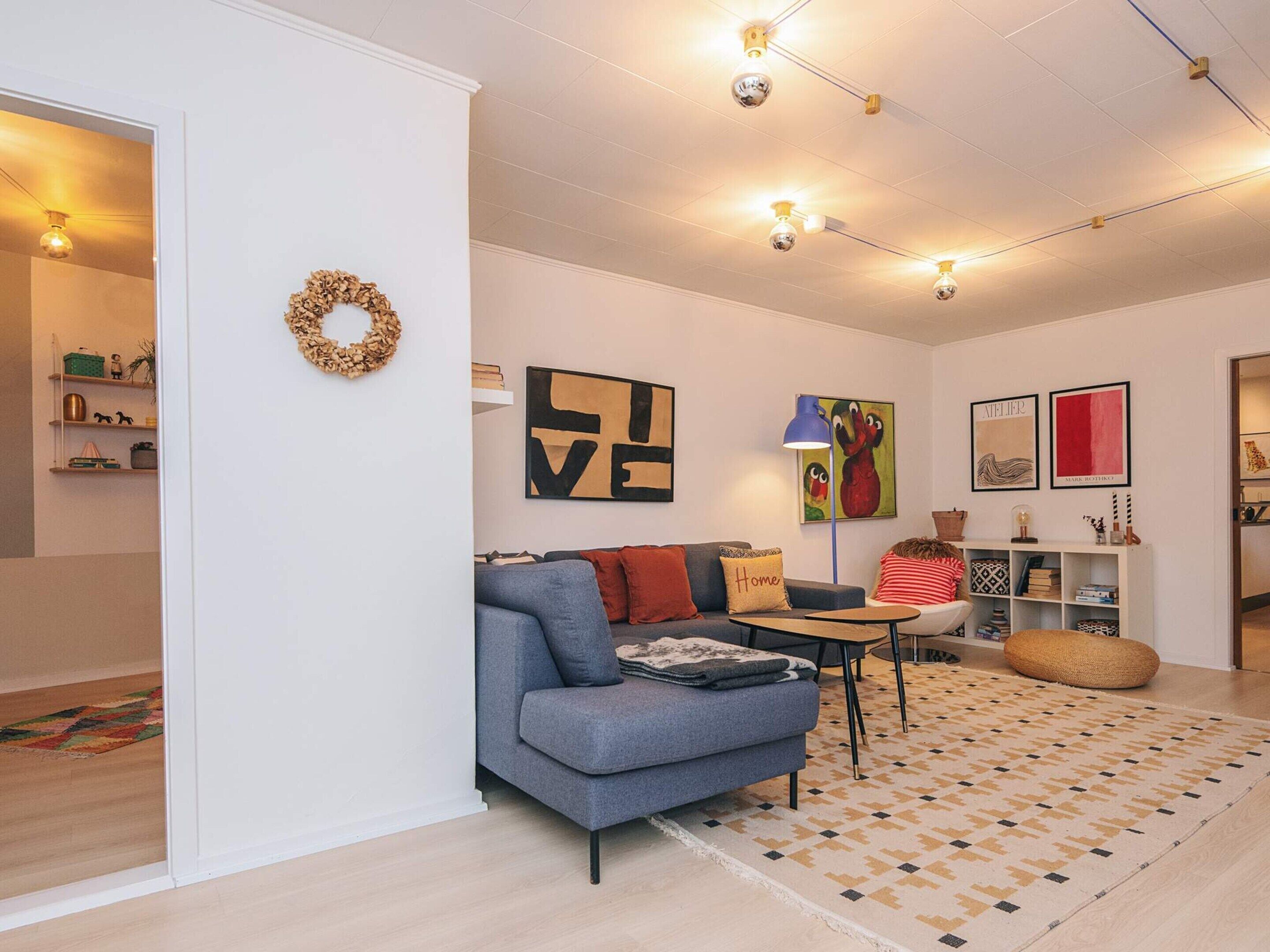 Un soggiorno moderno con un divano grigio, un tavolino e un tappeto decorato.