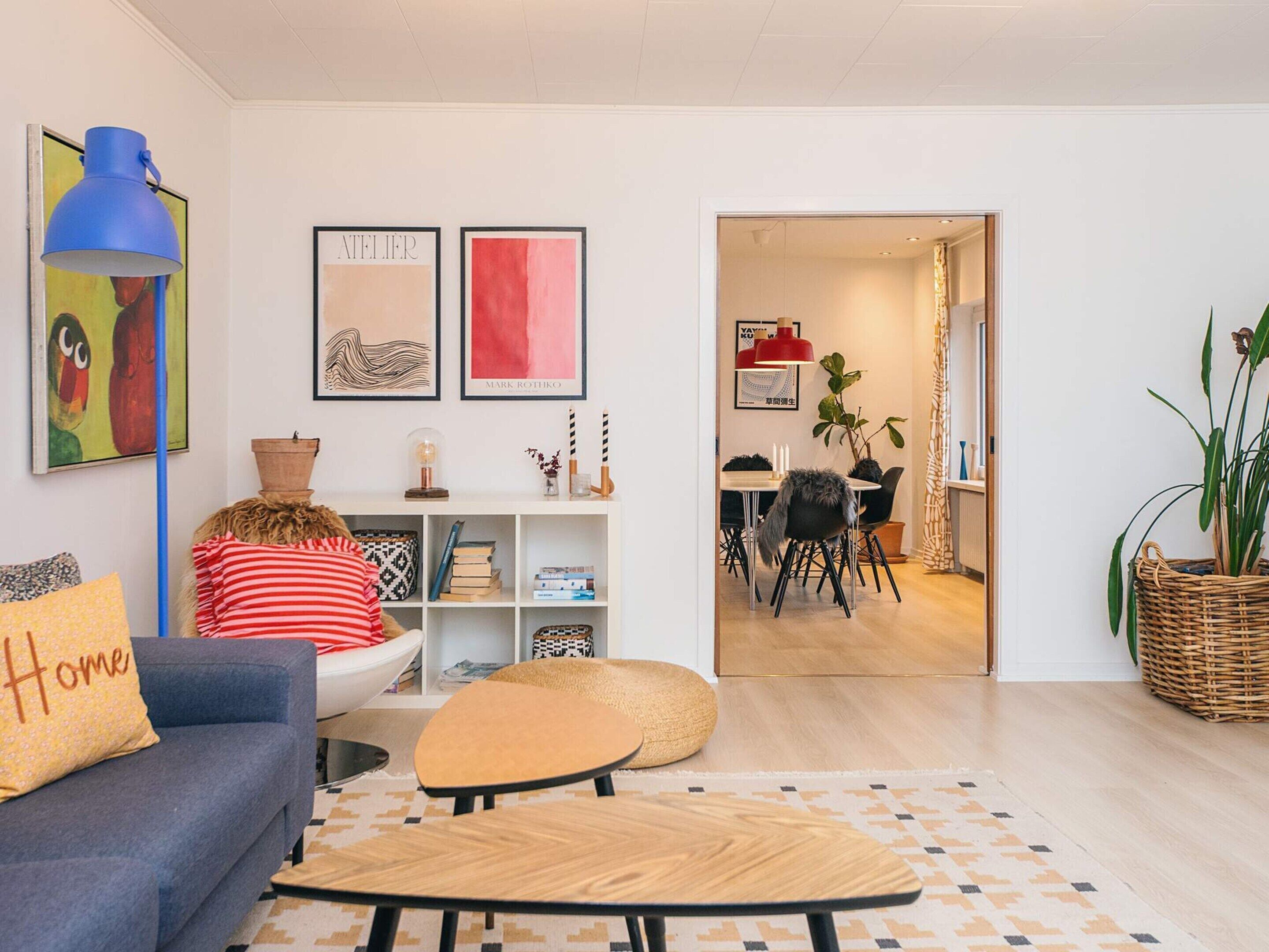 Una sala moderna con un sofá, una mesa de centro y un comedor con sillas y una mesa.