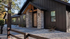 A modern building with a stone facade, wooden accents, and a gravel driveway. - New Luxury 3-bedroom Cabin in Big Bear Lake with Hot tub,EV Charger,Pool Table (Big Bear Lake)