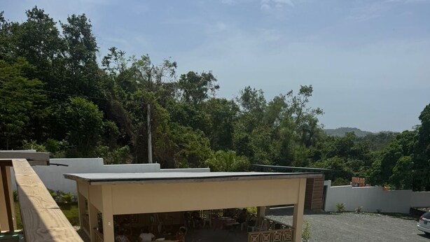 A swimming pool with a hot tub, wooden deck, and a covered seating area with tables and chairs. - 3-bedroom villa in welcoming Puerto Plata with AC and Fans (puerto plata)