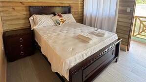 A wooden-paneled bedroom with a bed, a nightstand, and a ceiling fan. - 3-bedroom villa in welcoming Puerto Plata with AC and Fans (puerto plata)