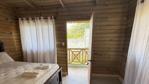 A bedroom with a bed, a ceiling fan, and a view of an outdoor balcony. - 3-bedroom villa in welcoming Puerto Plata with AC and Fans (puerto plata)