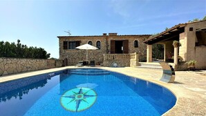 A swimming pool with a stone wall and a stone building in the background. - Country House 'Ca'n Jutger' with Private Pool, Private Terrace and Wi-Fi (Artà)