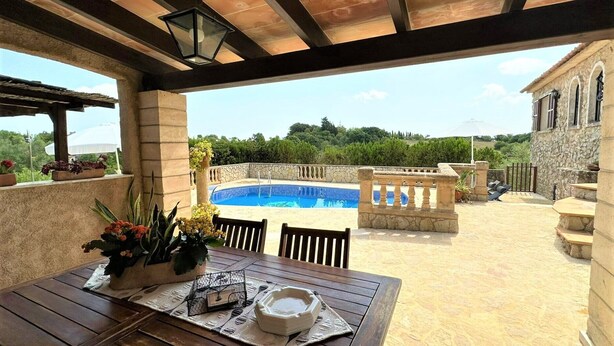 A covered patio with a pool, stone walls, and outdoor furniture. - Country House 'Ca'n Jutger' with Private Pool, Private Terrace and Wi-Fi (Artà)