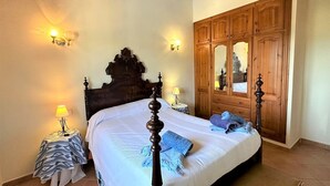 A bedroom with a wooden bed frame, a large mirror, and two bedside lamps. - Country House 'Ca'n Jutger' with Private Pool, Private Terrace and Wi-Fi (Artà)