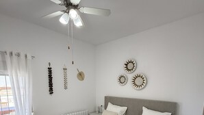 A bedroom with two beds, a ceiling fan, a window with curtains, and wall decorations. - Luxury family villa with private saltwater pool & casita near Alicante (Busot)