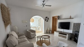 A living room with a sofa, armchairs, a TV, and a fireplace. - Luxury family villa with private saltwater pool & casita near Alicante (Busot)