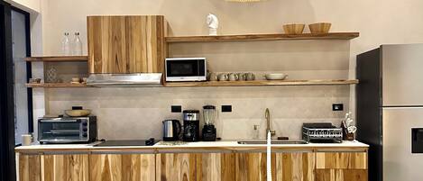 A modern kitchen with wooden cabinets, a microwave, and a dining area with a round table and chairs.