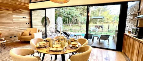 Un comedor moderno con una mesa redonda dispuesta para seis personas, rodeada por seis sillas.