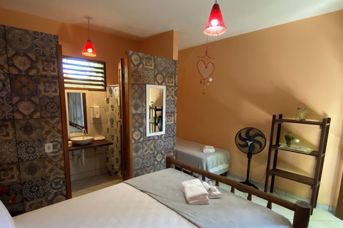 A bedroom with a bed, bedside table, and a mirror.