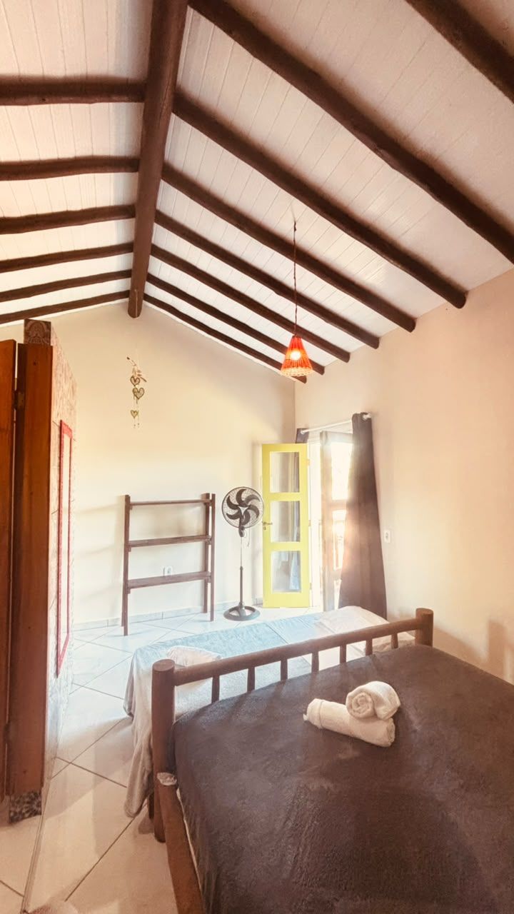 Una habitación con cama, escalera, ventilador y puerta.