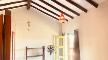 Una habitación con cama, escalera, ventilador y puerta.