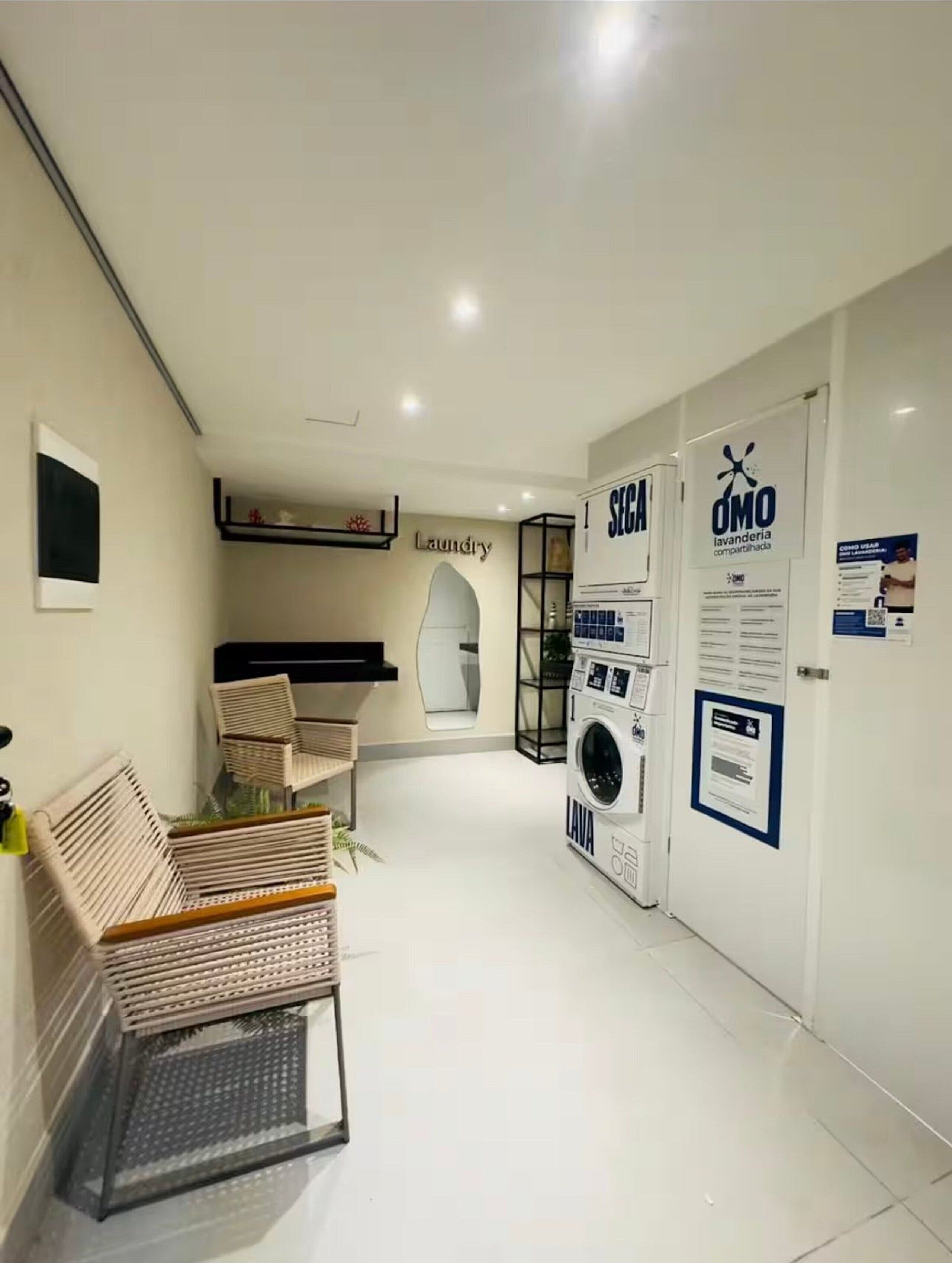 Un espace moderne dédié à la buanderie, comprenant un lave-linge, un étendoir et une chaise.