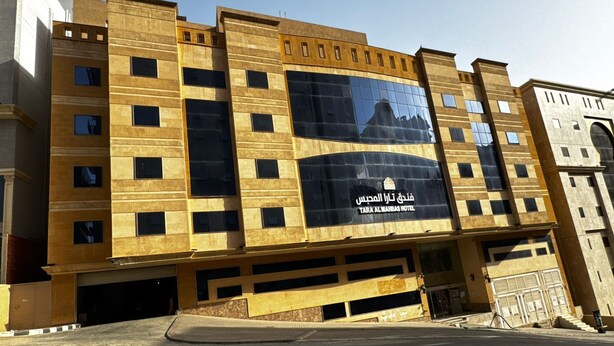 Un hôtel moderne doté d’une grande façade réfléchissante, de nombreux étages et d’une entrée imposante.