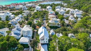 Vista aérea de uma área residencial costeira com casas, ruas e uma praia.