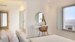 Ein modernes Schlafzimmer mit einem großen Bett, einem weißen Schreibtisch, einem runden Spiegel und Blick auf die Stadt durch ein großes Fenster.