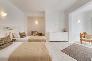 A hotel room with two beds, a white wardrobe, a wooden chair, and a small table. - Mykonos Seaview Villa Alea (Mykonos)