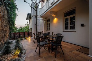 A patio with outdoor furniture, a brick wall, and a tree. - Celtic Lodge (Viseu)