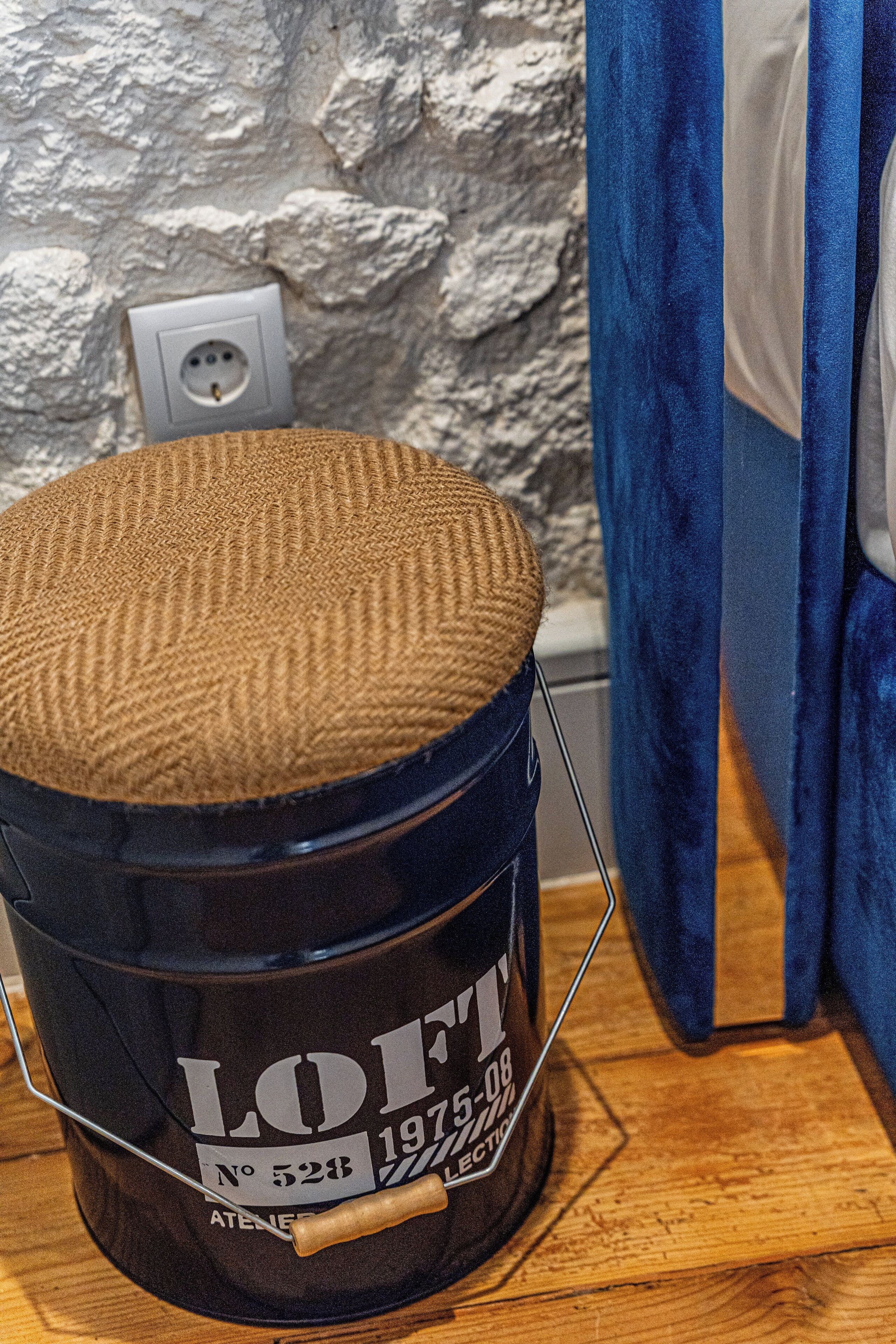 Un cubo de estilo vintage con tapa texturizada, sobre una superficie de madera.