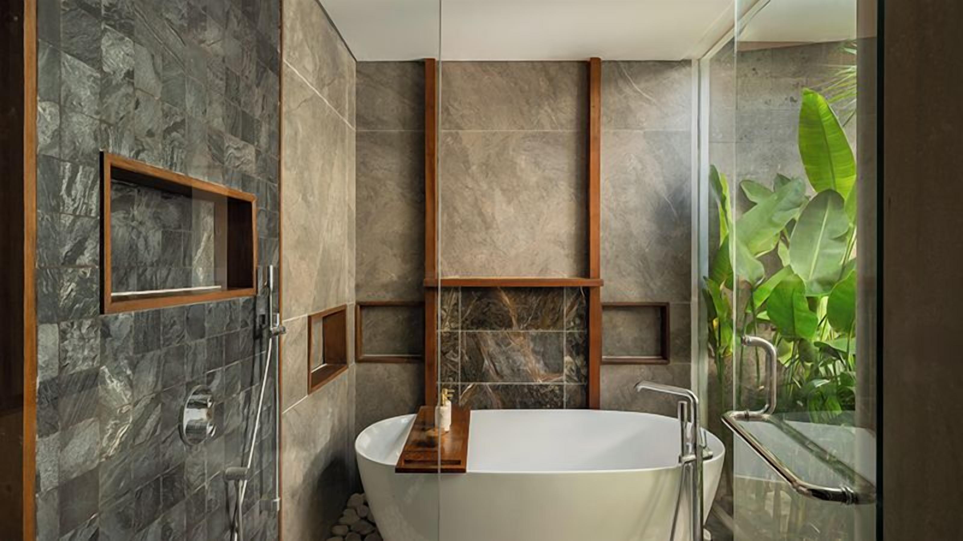 A modern bathroom with a freestanding bathtub, a glass shower enclosure, and a view of greenery.